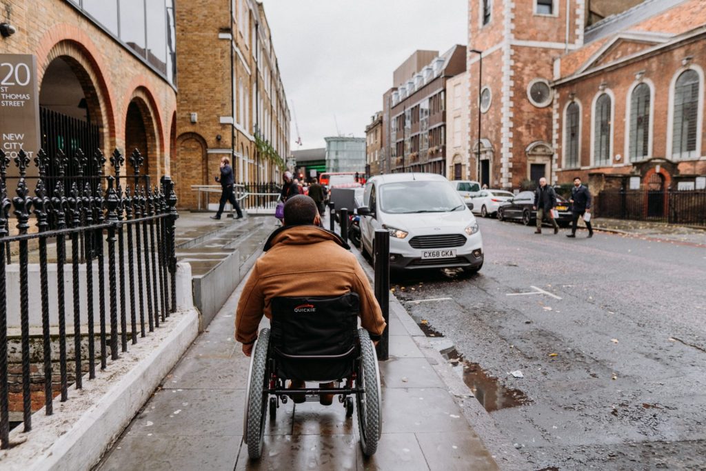Wesley Hamilton traveling solo in his wheelchair on a wet London street during a Beyond Barriers trip